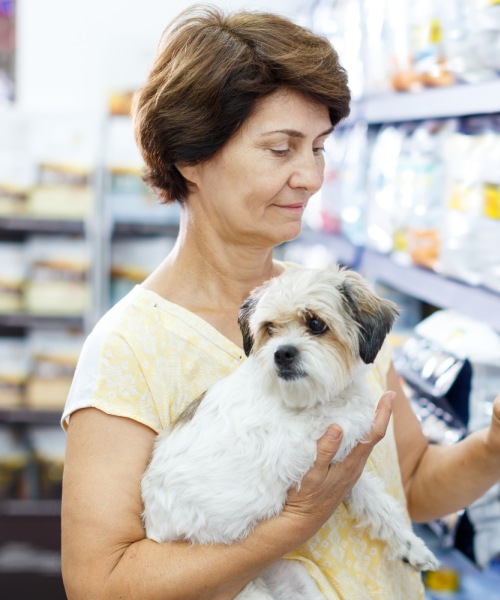 Woman holding small dog in store